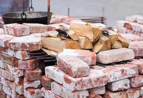 Folded brazier of bricks in lime, heat resistant with a stock of birch firewo Stock Photos