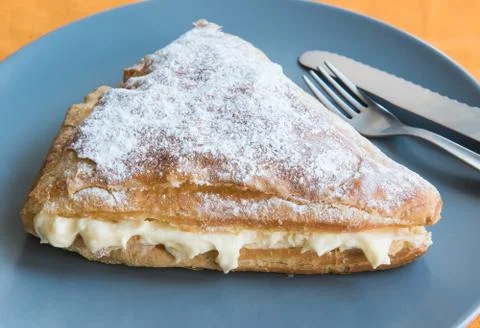 Folded bun triangle with cream on a gray plate Stock Photos