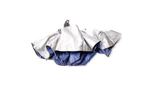 A folded compact umbrella with a silver outer layer and blue inner lining r.. Stock Photos