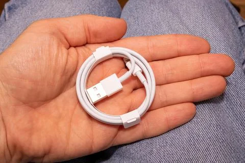 Folded connection data USB to lightning cable in mens hand Stock Photos