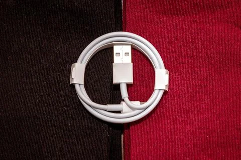 Folded connection data USB to lightning cable on textile background Stock Photos