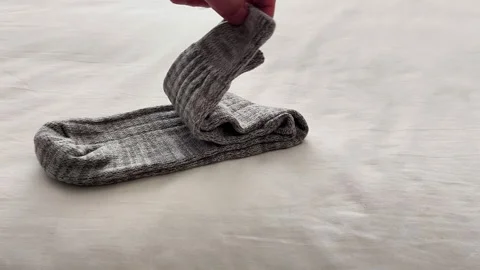 Folded Gray Ribbed Socks Resting on Soft Light Fabric Surface Display Video stock 326095509
