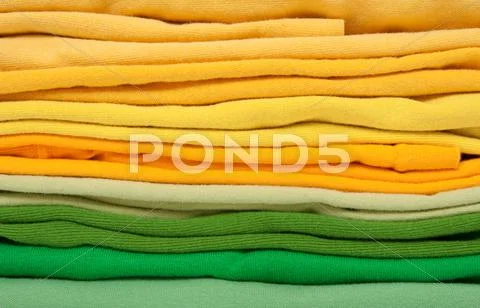 Folded green and yellow clothes Stock Photos