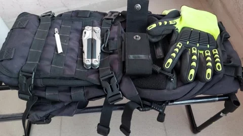 Folded heavy duty multitool lying on black tactical backpack background Stock Footage 346248317