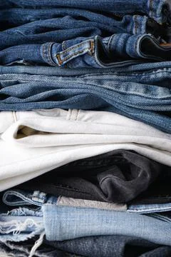 Folded jeans on gray background. Close-up. Vertically. Foto stock