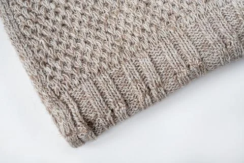 Folded knitted gray wool blanket. Edge of the gray knitted blanket on a whi.. Stock Photos