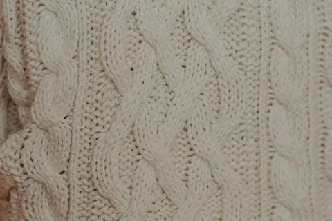 Folded knitted woolen sweaters, stack of old books on a cozy fluffy beige bla Stock Photos