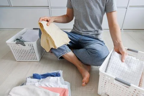 Folded laundry, home laundry, and clothing organization. A person holds nea.. Stock Photos