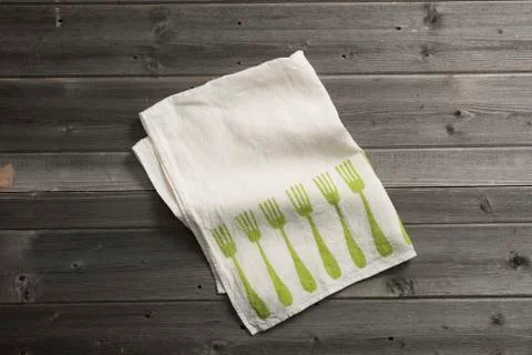 Folded Napkin with Green Fork Pattern on Wooden Surface Stock Photos