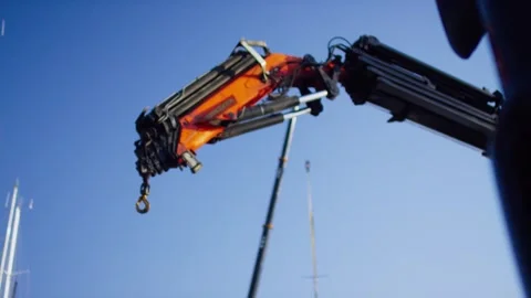 Folded Orange Hydraulic Loader Crane Boom, Marina Against Blue Sky, Low Angle Vidéo 340332374