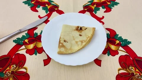 Folded Pancake on Festive Tablecloth with Knife in Holiday Setup Stock-Footage 325423398