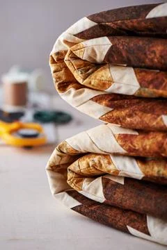 Folded patchwork blanket on white wooden surface on sewing accessories back.. 스톡 사진