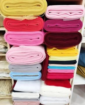 Folded rolls of multi-colored lightweight fabric with expressive texture Stock Photos