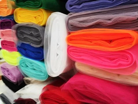 Folded rolls of multi-colored lightweight fabric with expressive texture Stock Photos