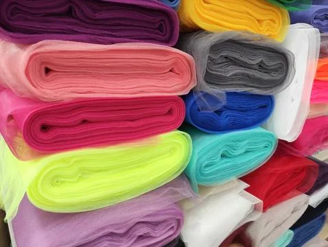 Folded rolls of multi-colored lightweight fabric with expressive texture Stock Photos