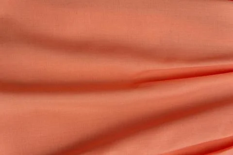 Folded texture of pink or peach fabric in waves. Natural material for sewing  Foto stock