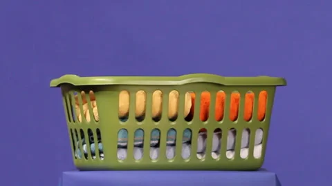 Folded towels falling into laundry basket Stock Footage 191314021