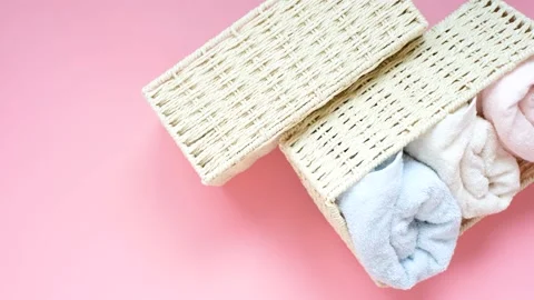 Folded towels in a wicker box close-up on a pink background, storage concept. Stock Footage 202051004