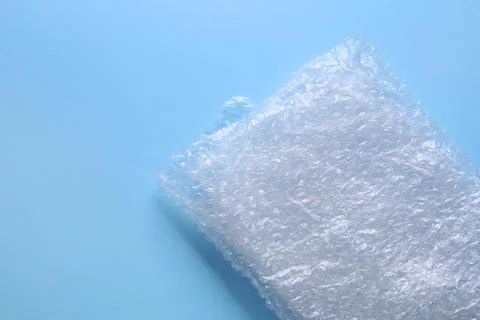 Folded transparent bubble wrap on light blue background, top view. Space fo.. Foto stock