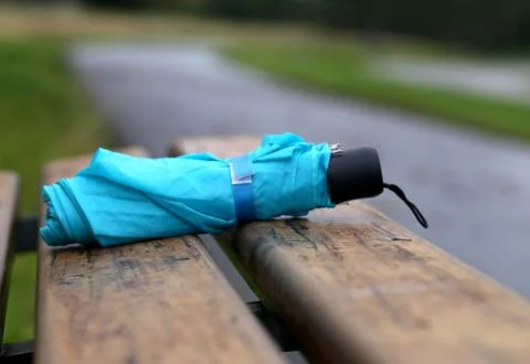 Folded umbrella on a bench Stock Photos