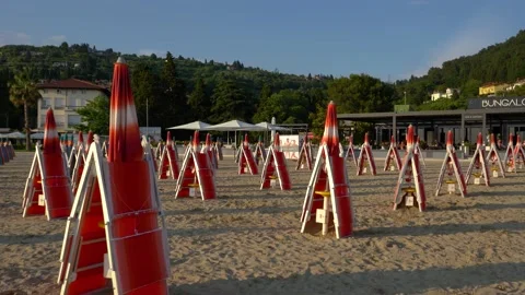 Folded up umbrellas and empty sun loungers in the evening on Portoroz beach Stock Footage 156259084