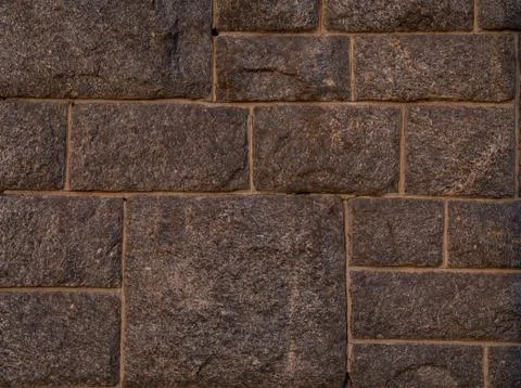 Folded wall surface of the rectangular square of rough stones smooth brown Stock Photos