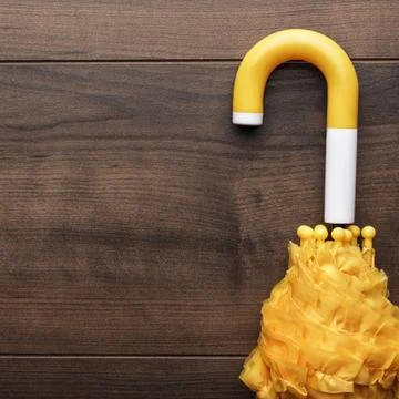 Folded yellow umbrella on the table Stock Photos
