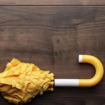 Folded yellow umbrella on the table Stock Photos
