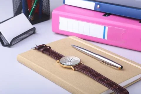 Folder file, note, pen and watch on the desk. blurred background. Stock Photos