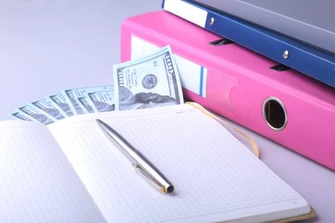 Folder file, note, pen and money on the desk. blurred background. Stock Photos