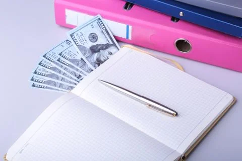 Folder file, note, pen and money on the desk. blurred background. Stock Photos