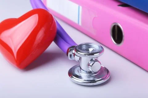 Folder file, stethoscope, red heart and RX prescription on the desk. blurred Stock Photos