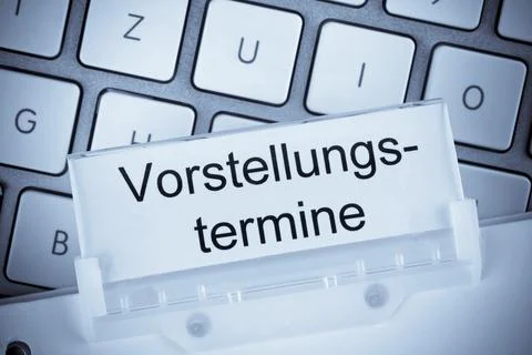 The folder of a hanging file in front of a computer keyboard on the subject of Stock Illustration