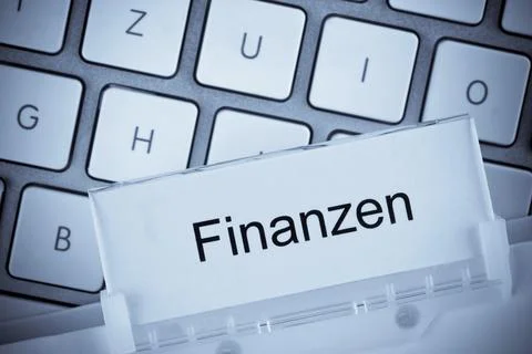 The folder of a hanging file in front of a computer keyboard on the subject of Stock Photos