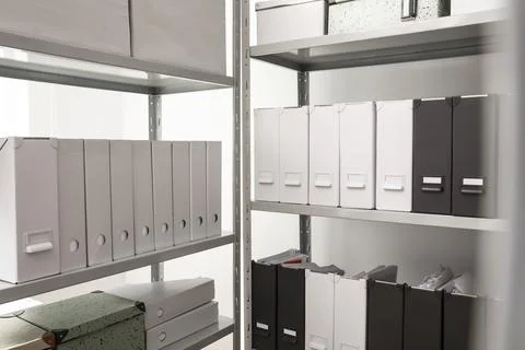 Folders and boxes with documents on shelves in archive Stockfoto's