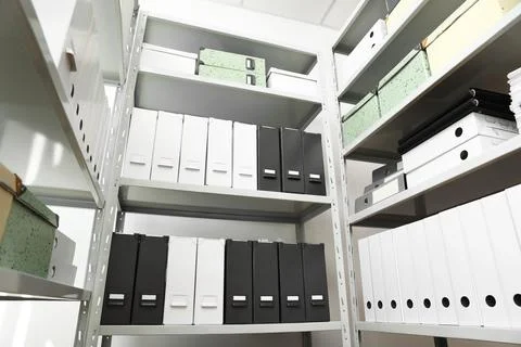 Folders and boxes with documents on shelves in archive, low angle view Stockfoto's