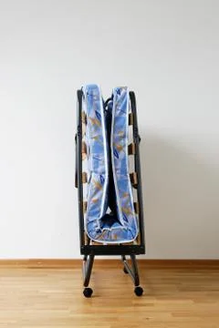 A folding bed in front of a white wall Stock Photos