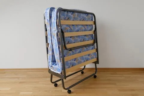 A folding bed in front of a white wall Stock Photos