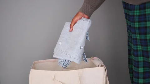 Folding clothes and putting them in a laundry basket Stock Footage 340940150