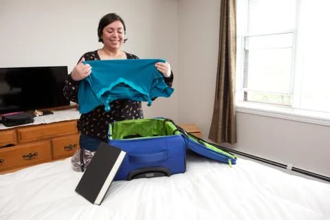 Folding clothes into suitcase Stock Photos
