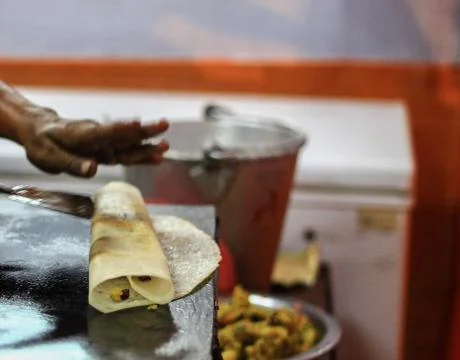 Folding dosa after adding potato masala to make masala dosa on a frying pan Stock Photos