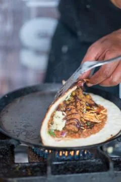 Folding Dosa While Cooking on a Hot Skillet Foto stock