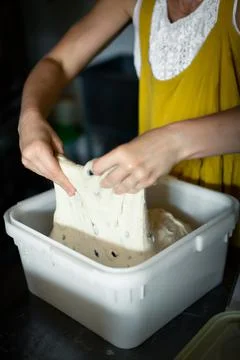 Folding the dough in a container in a bakery Stock Photos