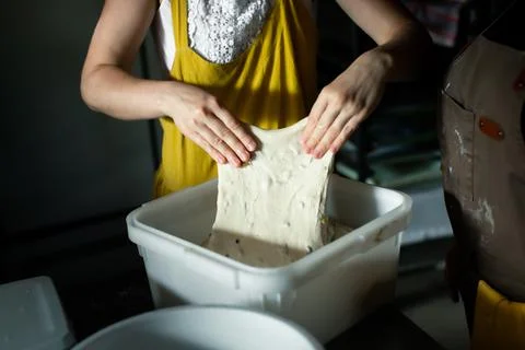Folding the dough in a container in a bakery Foto stock
