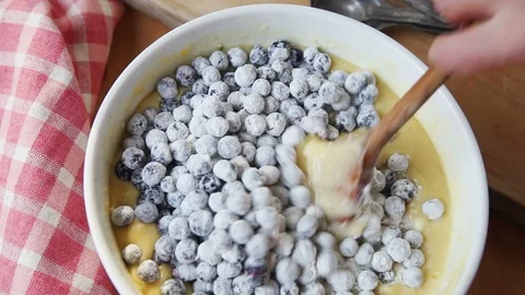 Folding floured blueberries into cake batter Stock Footage 99407014
