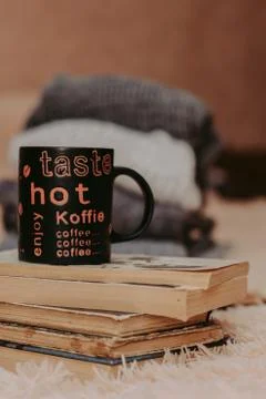 Folding knitted woolen sweaters, a stack of old books, a beautiful black and  Stock-Fotos