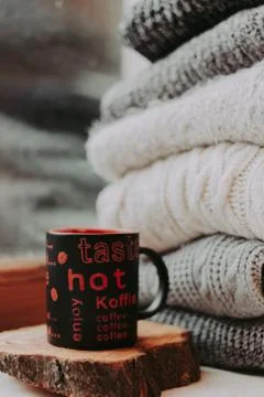 Folding knitted woolen sweaters, a stack of old books, a beautiful black and  Stock Photos