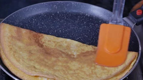 Folding omelet in to triangle with silicon spatula after cooking in non Stock Footage 255266022