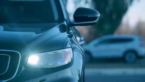 Folding out the rear view mirrors and lighting up the LED optics of black car Stock Footage 254977644