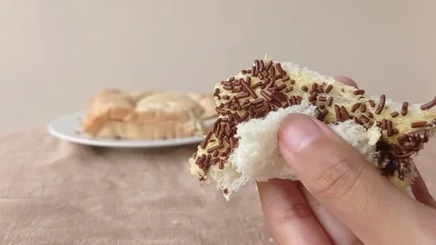 Folding a slice of bread with butter and chocolate sprinkles Stock Footage 146256693